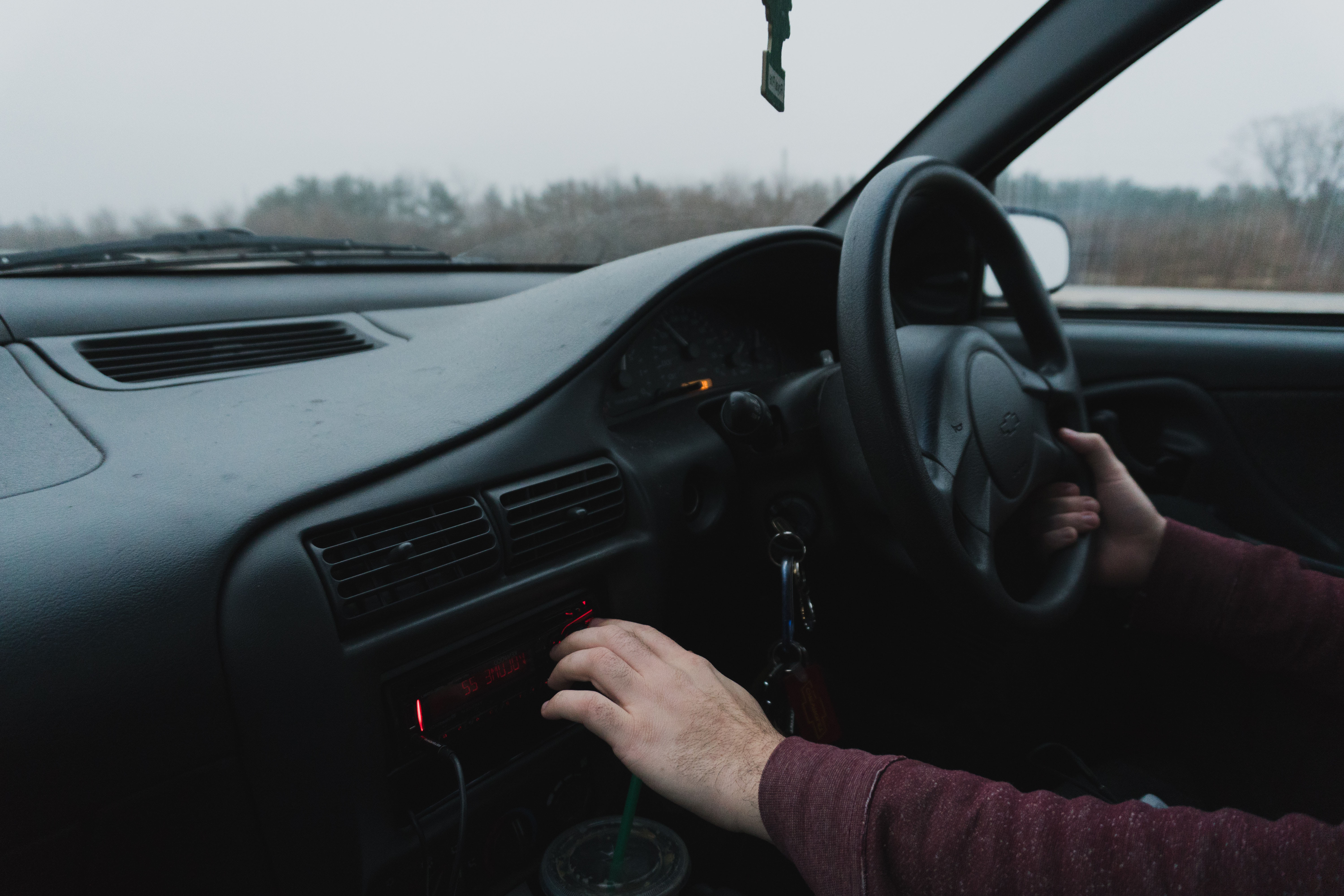 Photo of person driving while playing with radio