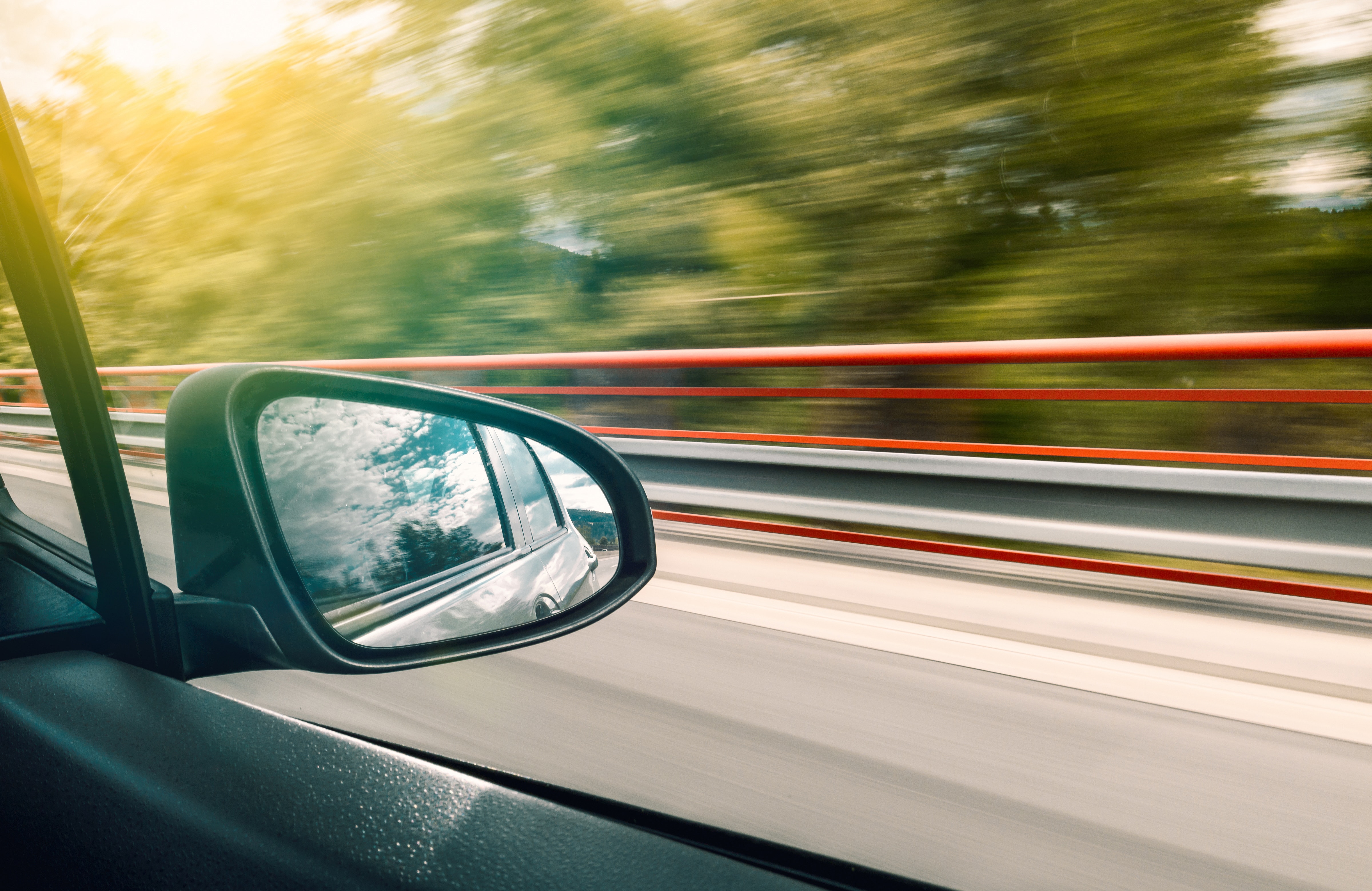 Photo of a car side-view mirror on motorway